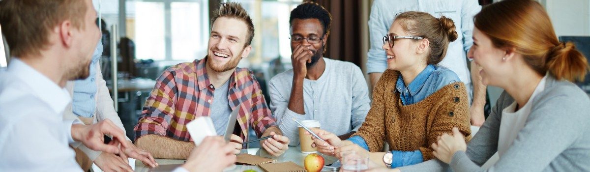 A group of cheerful employees discussing ideas at a table.